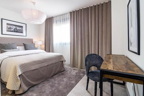 a bedroom with a bed and a table and a desk at INF42M- Modern city apartment, families only in Estepona