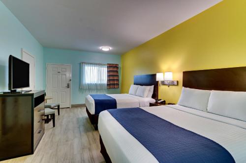 a hotel room with two beds and a flat screen tv at Island Hotel Port Aransas in Port Aransas
