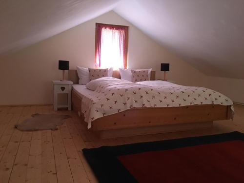 ein Schlafzimmer mit einem großen Bett und einem Fenster in der Unterkunft Homoród Lodge in Băile Homorod
