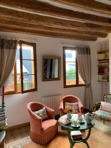 ein Wohnzimmer mit 2 Stühlen und einem Tisch in der Unterkunft Maison Léontine in Bernay