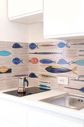 a kitchen with a wall of fish tiles at Residence Lì Galli in Praiano