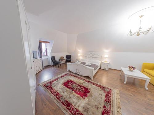 a white bedroom with a bed and a living room at Hotel Salamander - Garni in Banská Štiavnica