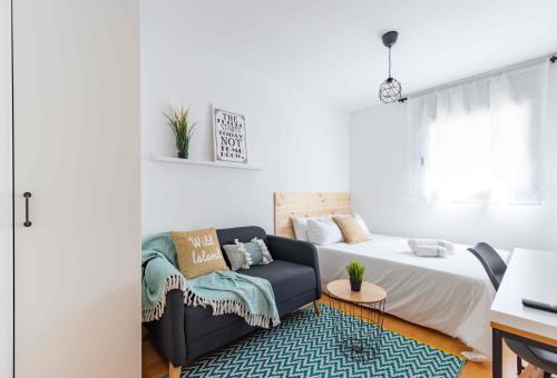 ein Wohnzimmer mit einem Bett und einem Sofa in der Unterkunft El Capricho Terrassa. in Terrassa