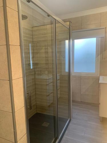 a shower with a glass door in a bathroom at El Balcón de la Roca in Setenil