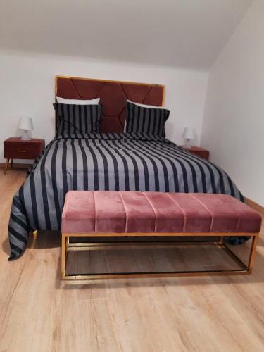 uma cama grande com um banco vermelho num quarto em Luxury suite maladiere 2 em Dijon