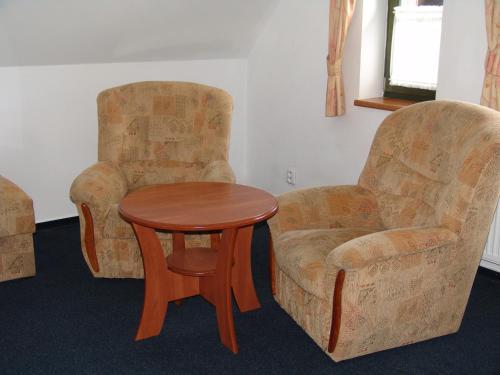 two chairs and a table and a table and a chair at Penzion Kamínek in Janske Lazne