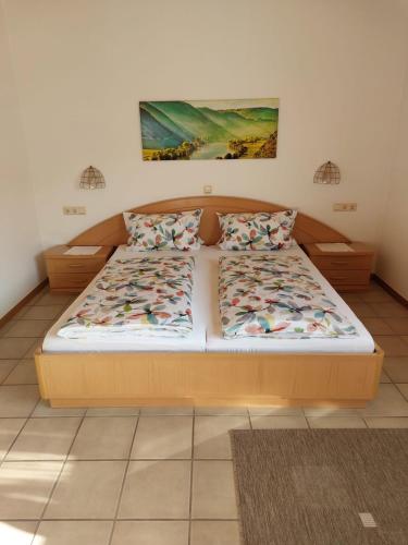 a bedroom with a bed with a wooden frame at Wein- und Gästehaus Hermes-Hoffmann in Trittenheim
