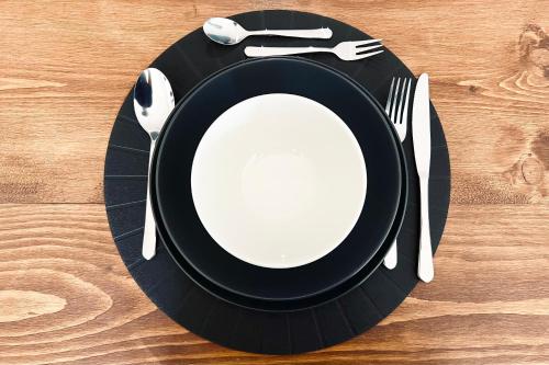 a black plate with a spoon and fork and a knife at APPT LANTON PLAGE - PORT 6 Voyageurs in Lanton