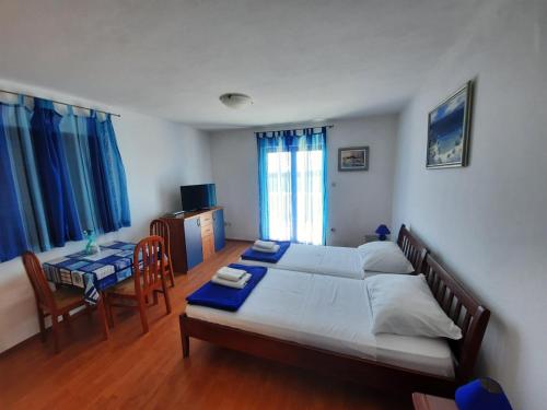 a bedroom with a bed and a table and chairs at Vila Mia in Prizba