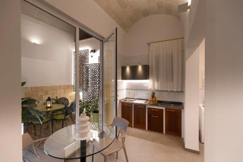 a kitchen with a glass table and a dining room at Palazzo Guajana in Trapani