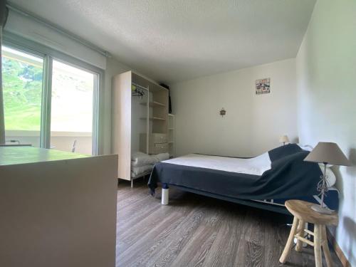 1 dormitorio con cama, mesa y ventana en Appt chaleureux 2 - 4 personnes au pied des pistes - draps et linges de toilette non fournis - ménage non inclus, en La Mongie