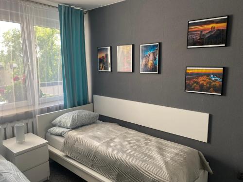 a bedroom with a bed and pictures on the wall at Apartament w ZIELONEJ OKOLICY z TARASEM in Kielce
