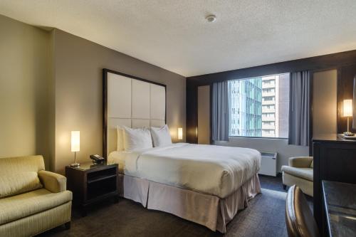 una camera d'albergo con letto e finestra di Arc The Hotel a Ottawa