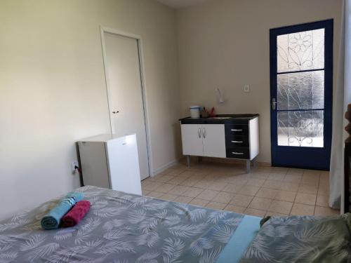 a bedroom with a bed and a refrigerator and a door at Benvivere - Indaiatuba - Seu descanso é aqui! in Indaiatuba