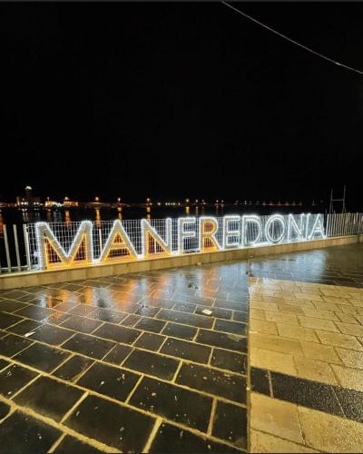 a lit up sign on a pier at night at Pietrabianca Apartments San Lorenzo in Manfredonia