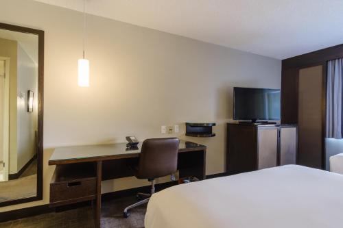 a hotel room with a bed and a desk with a computer at Arc The Hotel in Ottawa