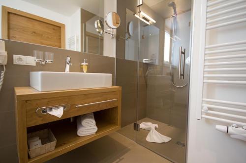 ein Bad mit einem Waschbecken und einer Dusche in der Unterkunft Berglife Appartements in Serfaus