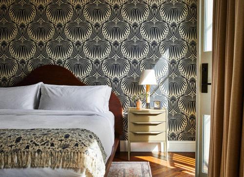 a bedroom with a bed and a black and white wallpaper at The Pinch Charleston in Charleston