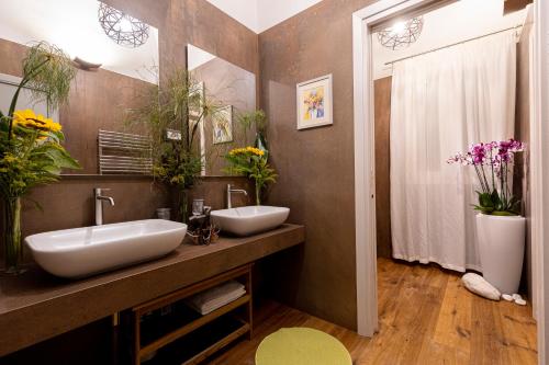 a bathroom with two sinks and plants on the wall at Palazzo Guajana in Trapani