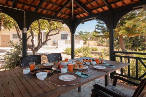 a wooden table with food on it on a patio at Villa Melenia for Family Holidays by the Beach in Agia Pelagia