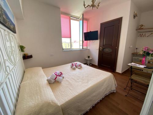 un dormitorio con dos animales de peluche sentados en una cama en B&B Napul'è, en Nápoles