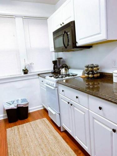 a kitchen with white cabinets and a stove top oven at (53.1S) Forest Park, The Zoo, and much more in Saint Louis