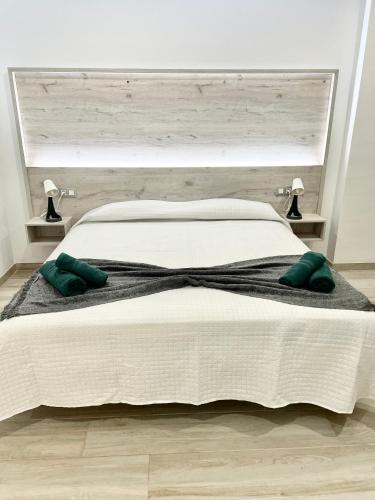 a bedroom with a large white bed with green pillows at ISLAND SUITES in Arona