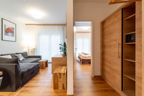 uma sala de estar com um sofá e uma mesa num quarto em Feldberg Lounge - Residenz Grafenmatt em Feldberg