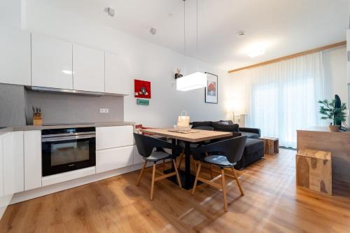 a kitchen and living room with a table and a couch at Feldberg Lounge - Residenz Grafenmatt in Feldberg