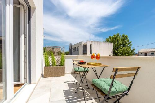 um pátio com uma mesa e cadeiras numa varanda em Bonaca apartments with terrace and private parking em Kaštela