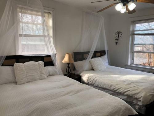 1 dormitorio con 2 camas y ventilador de techo en (49.1W) Beautiful Getaway in Saint Louis, en Benton