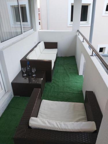 a balcony with two couches and a green floor at Apartments "4You" in Tivat