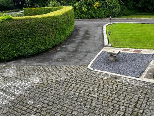 a stone bench sitting in the middle of a driveway at Castle House Holiday Home in Chapel en le Frith