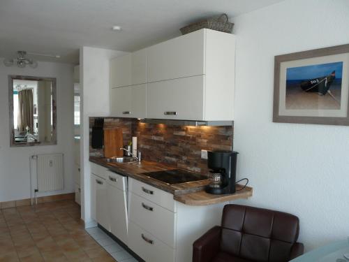 a kitchen with white cabinets and a counter top at 1 Raum Apartment "Das Boot" am Neuensiener See inklusive 2 Räder in Seedorf