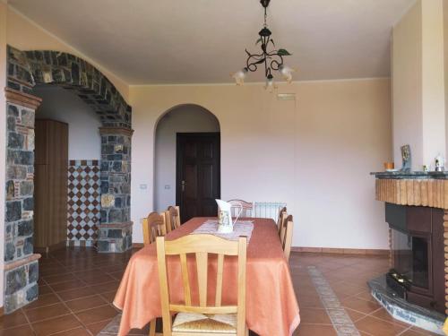 a dining room with a table and a fireplace at B&B Girasole in Torraca