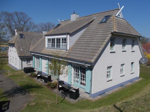uma casa branca com um telhado de gambrel em 1 Raum Apartment "Das Boot" am Neuensiener See inklusive 2 Räder em Seedorf