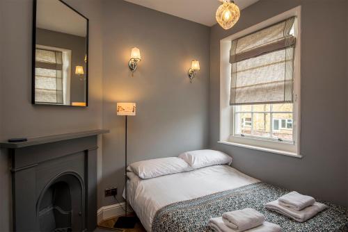 a small bedroom with a bed and a mirror at Coastal Cottage: Charming three bedroom cottage with private garden in Ramsgate