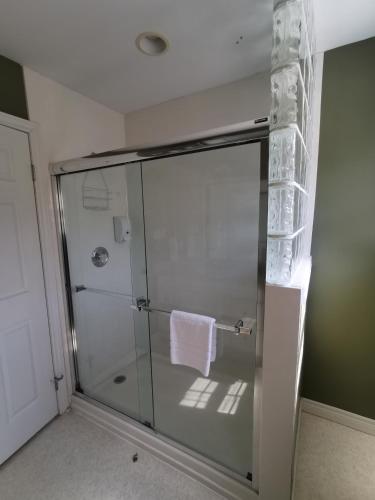a shower with a glass door in a bathroom at Inn on the Harbour and Telegraph House in Port Stanley