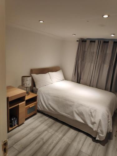 a bedroom with a large bed and a night stand at Highview in London