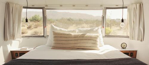 a bedroom with a bed with a large window at AutoCamp Joshua Tree in Joshua Tree