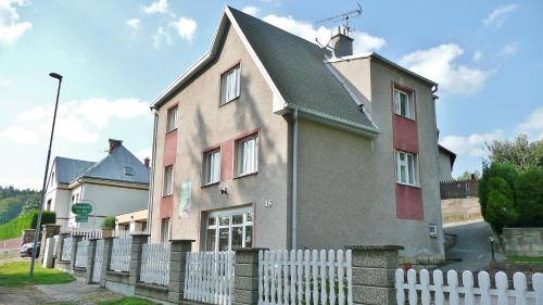 a house with a white fence in front of it at Penzion Prachov in Jičín