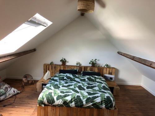 1 dormitorio con 1 cama con edredón verde en La MER, en Bredene