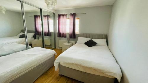 a small bedroom with two beds and a mirror at Modern City Centre House in Galway