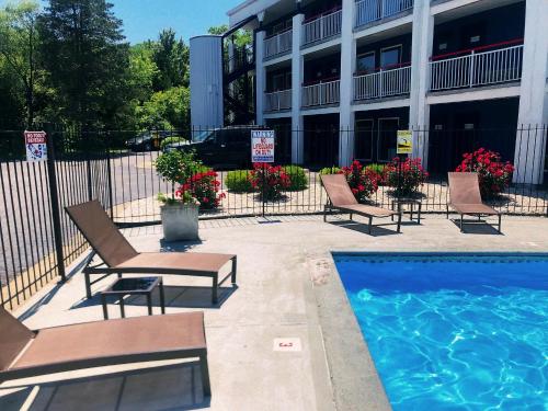 einem Pool vor einem Gebäude mit Stühlen neben einem Gebäude in der Unterkunft American Inn Kansas City, KS in Kansas City