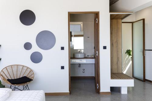 un dormitorio con una pared blanca con círculos grises. en DOMUS AESTAS Luxury Residences, en Plakias