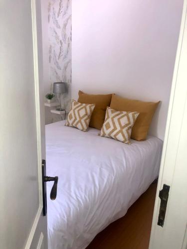 ein Schlafzimmer mit einem weißen Bett mit Kissen darauf in der Unterkunft City Break in Torres Vedras
