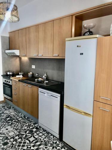 a kitchen with a white refrigerator and a sink at City Break by StaySalmar in Torres Vedras