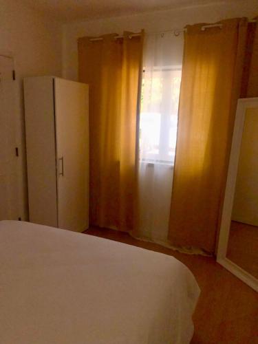 a bedroom with a bed and a window with curtains at City Break by StaySalmar in Torres Vedras