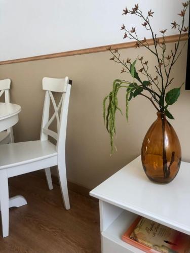 a vase with a plant on a table next to a chair at City Break by StaySalmar in Torres Vedras