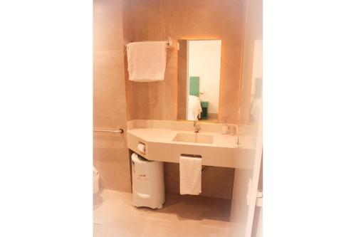 a bathroom with a sink and a mirror at Casa d'Aroeira Residencial Boutique - Centro de Juqueí - 2 quadras do mar - Serviço de Praia - Roupa de Cama 600 fios algodão Egípcio - Toalhas Banho e Praia - Tudo Novo - Estacionamento Interno - Cozinha - Consulte unidades com Ofurô Hidro e Cromoterapia in Juquei